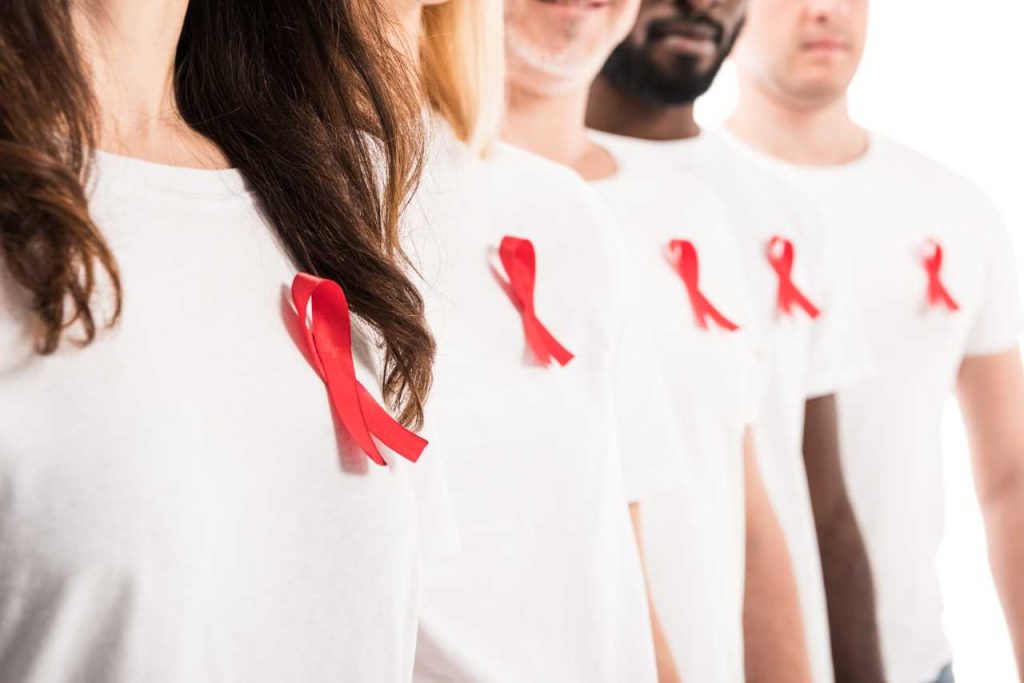 personas con camiseta blanca y lazo rojo