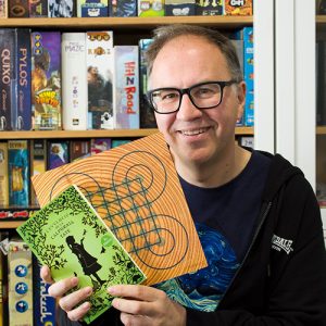 Retrato del especialista español Oriol Ripoll rodeado de libros y juegos. 